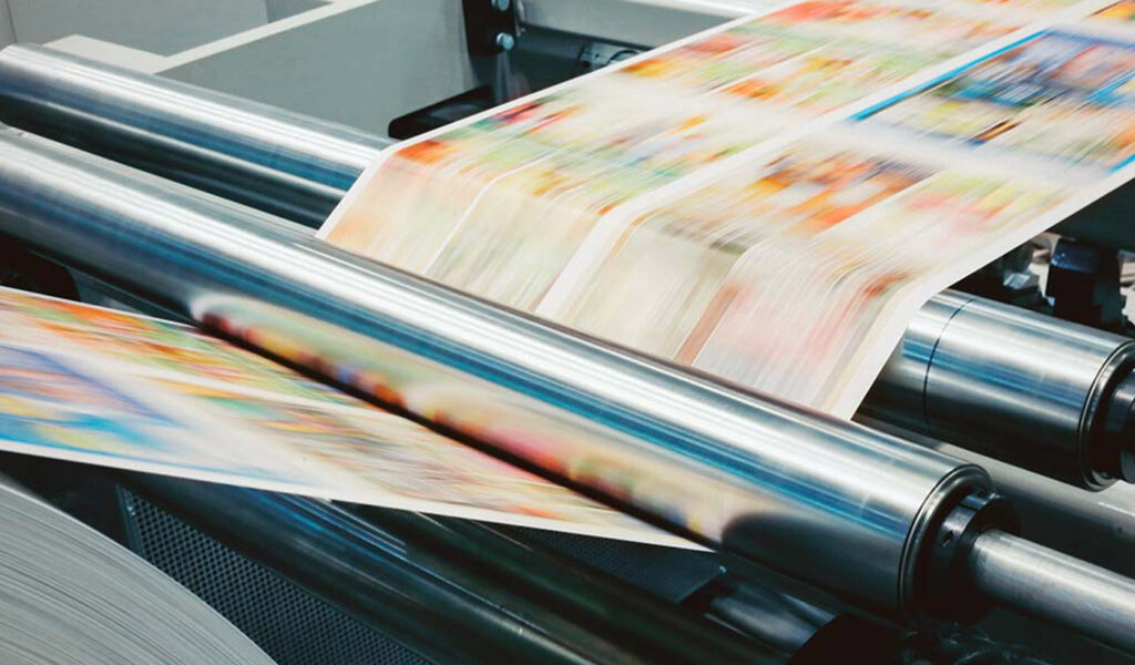 Commercial printer with color pages being printed.