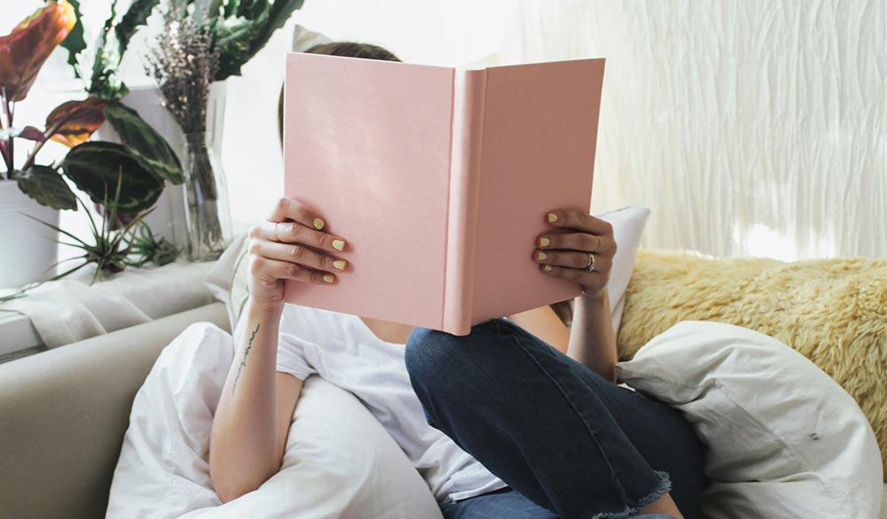 Female Book Lover Holding a Pink Book