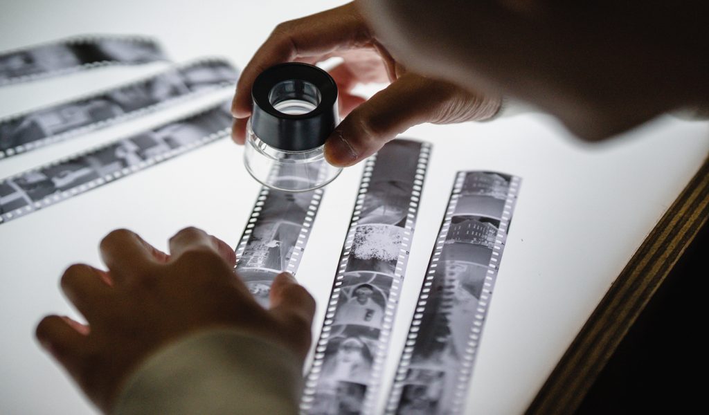 Photographer looking at film to choose their favorite images.