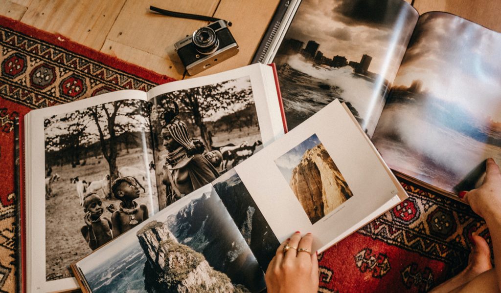 Three photography portfolios layer on top of each other on the floor.