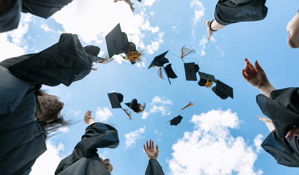 Graduates throwing their caps in the air: yearbook picture.