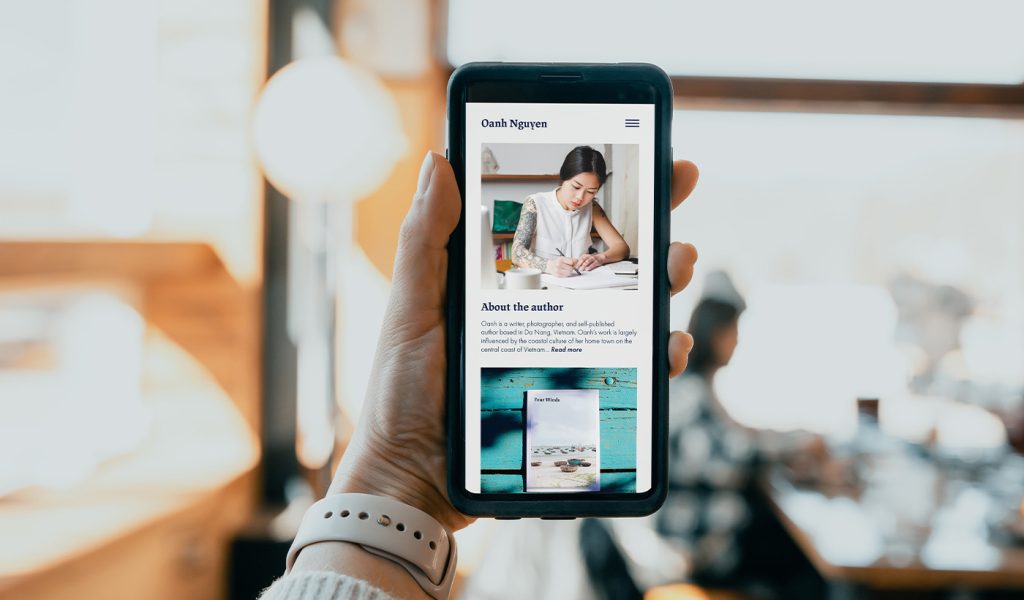 Author looking at their author website on a phone that they'll use to promote their self-published book