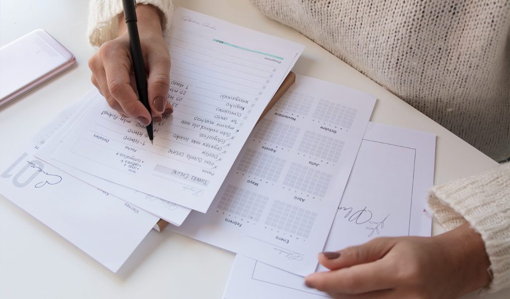 Custom planner at home with someone writing a to-do list and looking at a calendar.