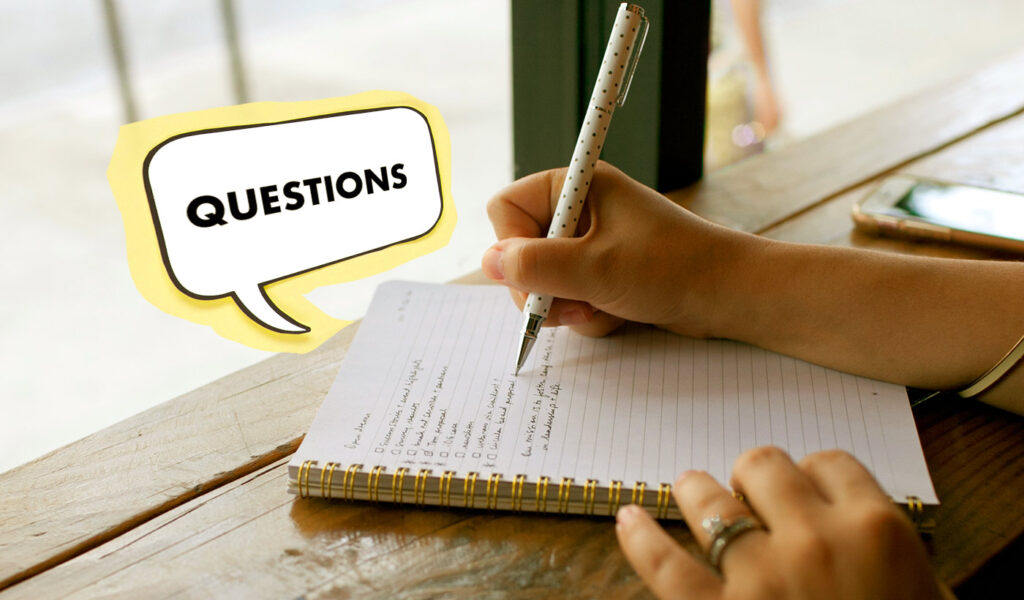 Mentee writing questions in a notebook to ask mentor.