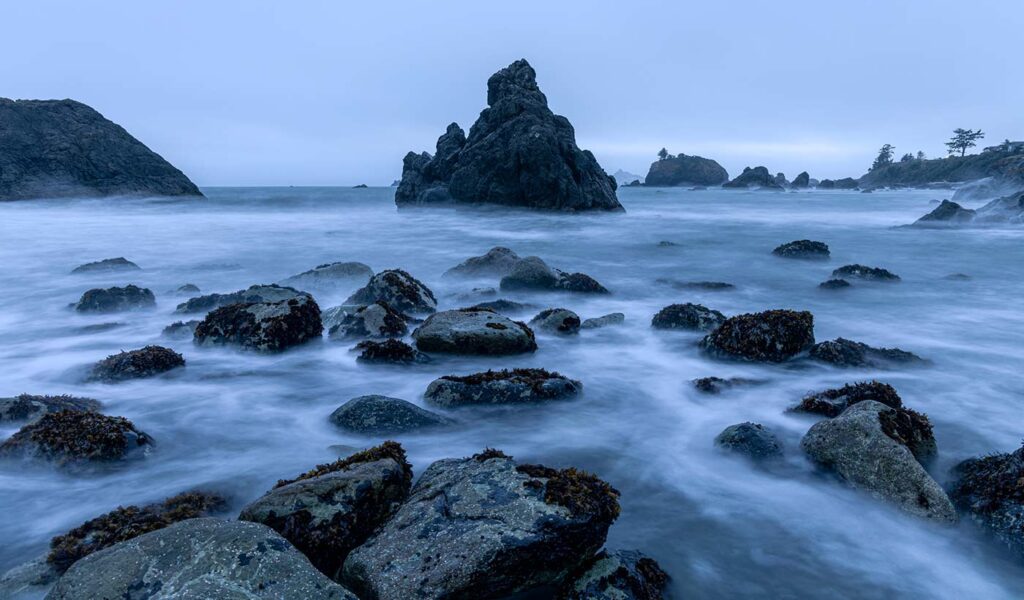 Slow motion water flowing through rocks at beach