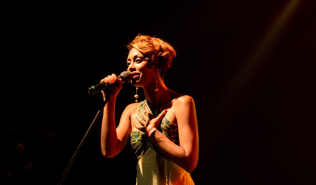 Woman on stage reciting poetry.