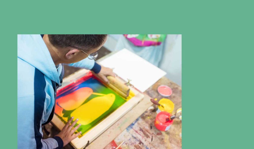 Person using a type of printing called screen printing