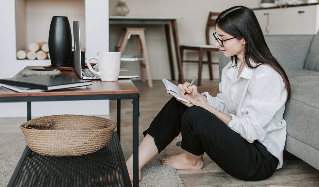 Woman sitting on the floor writing a poem