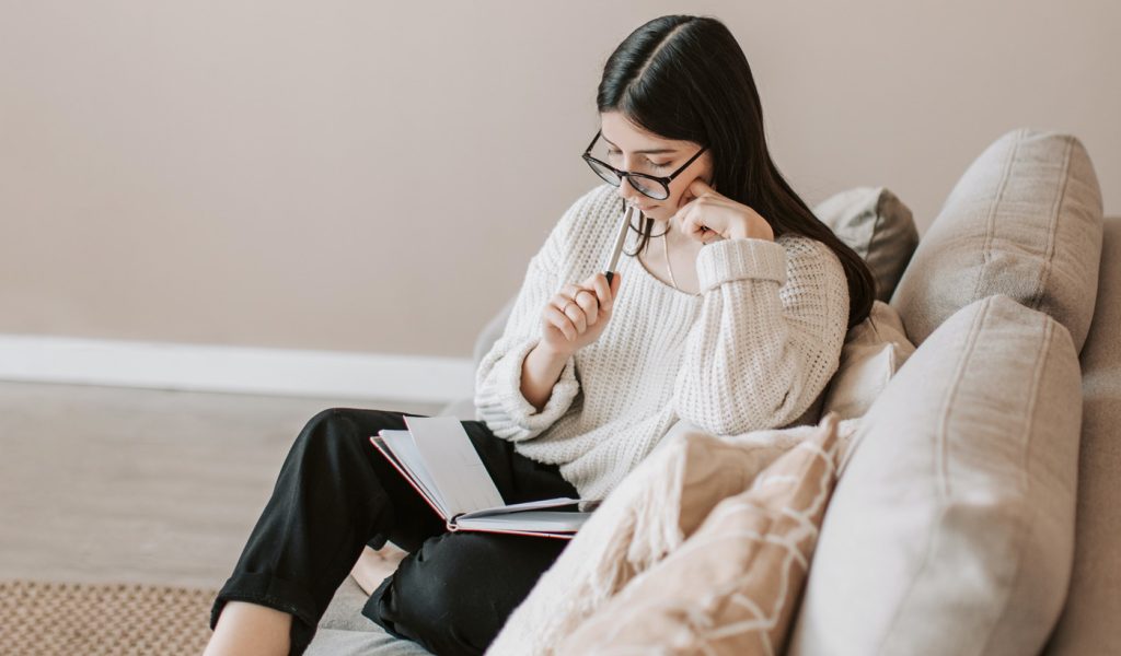 Author sitting on a couch studying important literary devices