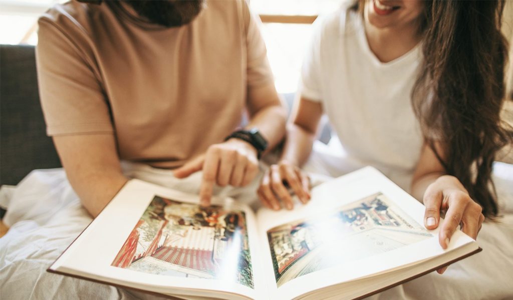 Two people going through a photo book telling a photo story