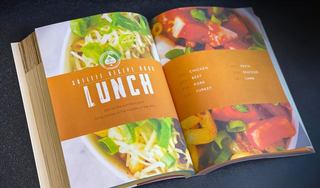 A photo of the Official SOFLETE Recipe Book open on a chapter title page. 