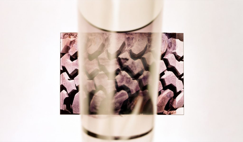 Clear cup with a photograph of a brick wall directly behind it