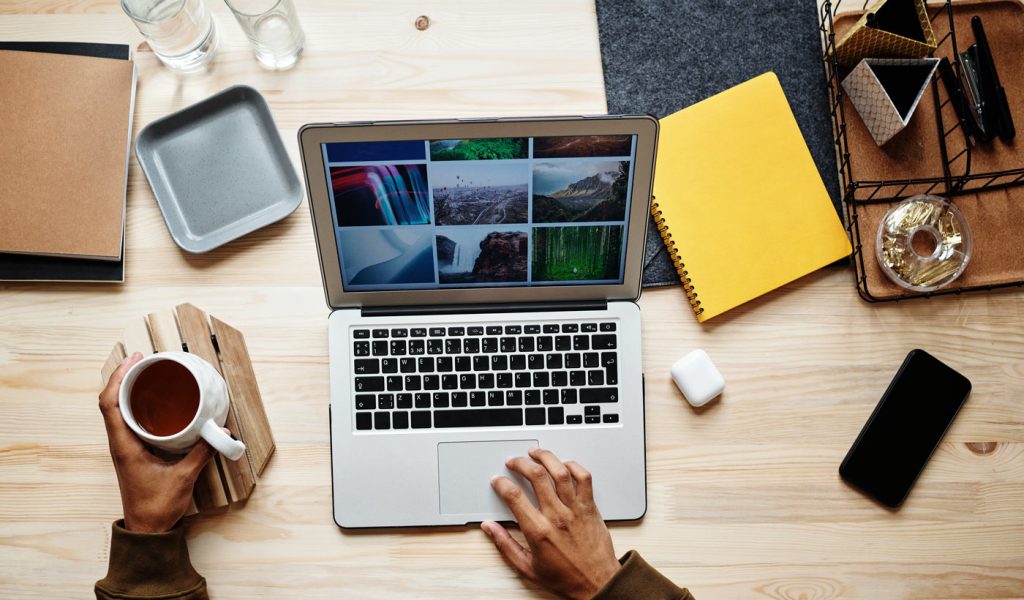 Photographer working on their branding on a computer with coffee