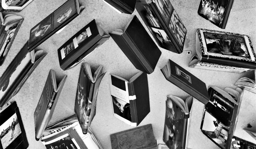 Black and white photograph of books spine side up