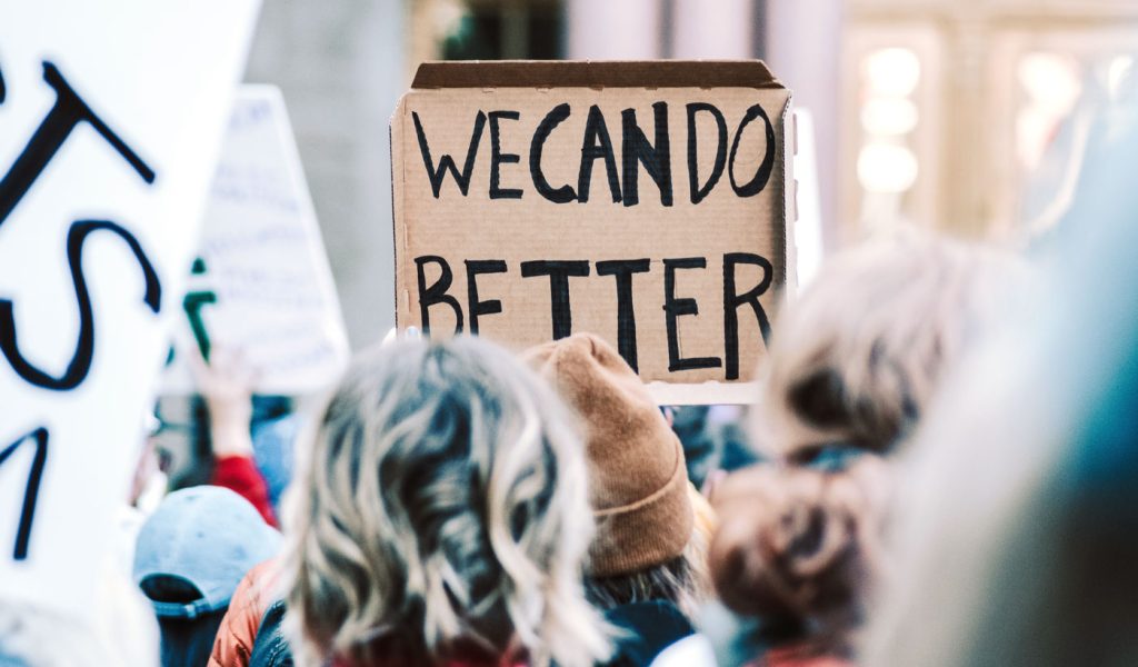 Protest photo with a sign saying "we can do better"