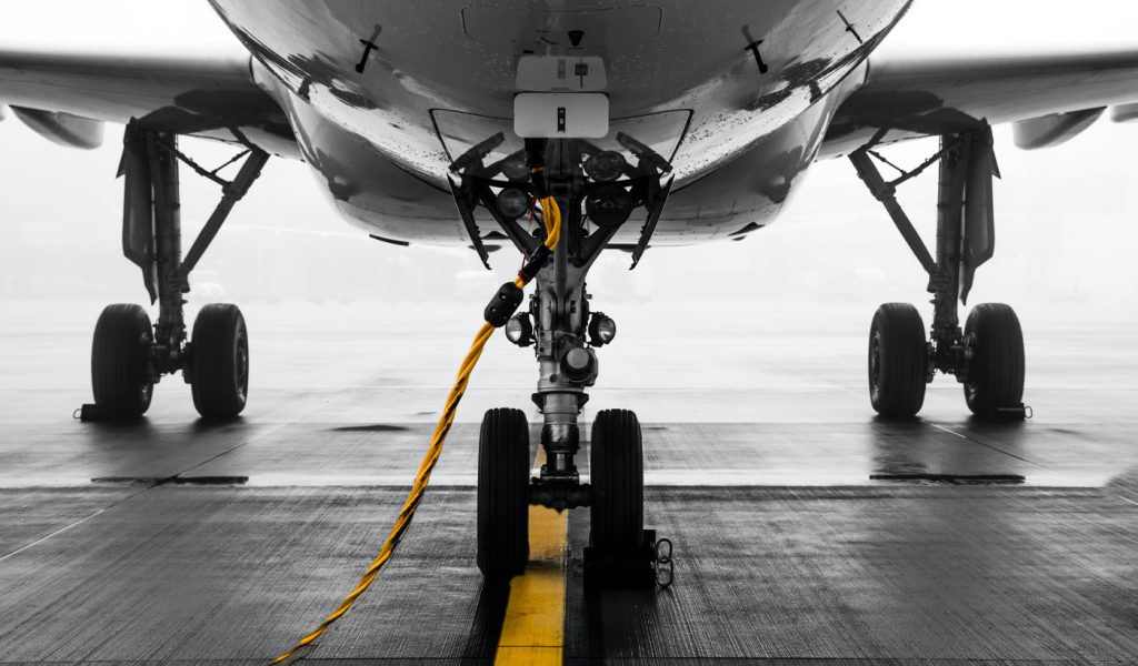 Color pop photography with a black and white plane and a yellow landing strip