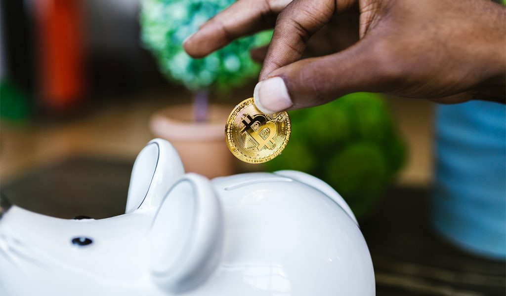 Comic book creator adding a golden coin into a piggy bank.