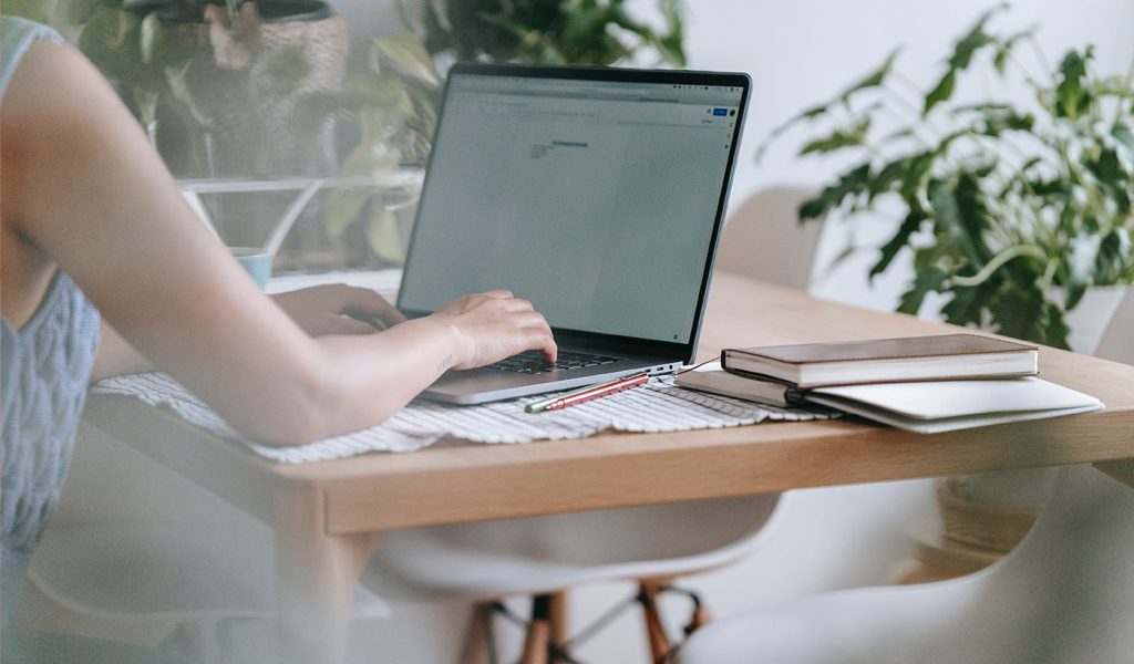 Person sitting at a desk writing a newsletter