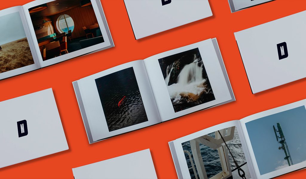 Many photo books open on an orange background.