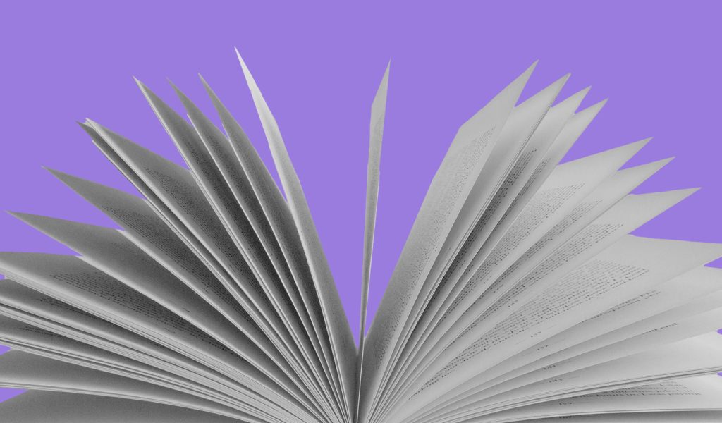 A book with pages fanned out on a purple background