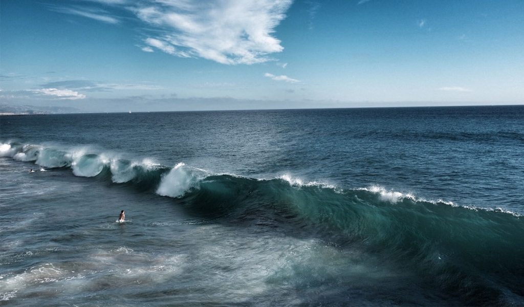 Photograph of a surfer waiting for a wave—a great example of how photographers should be patient