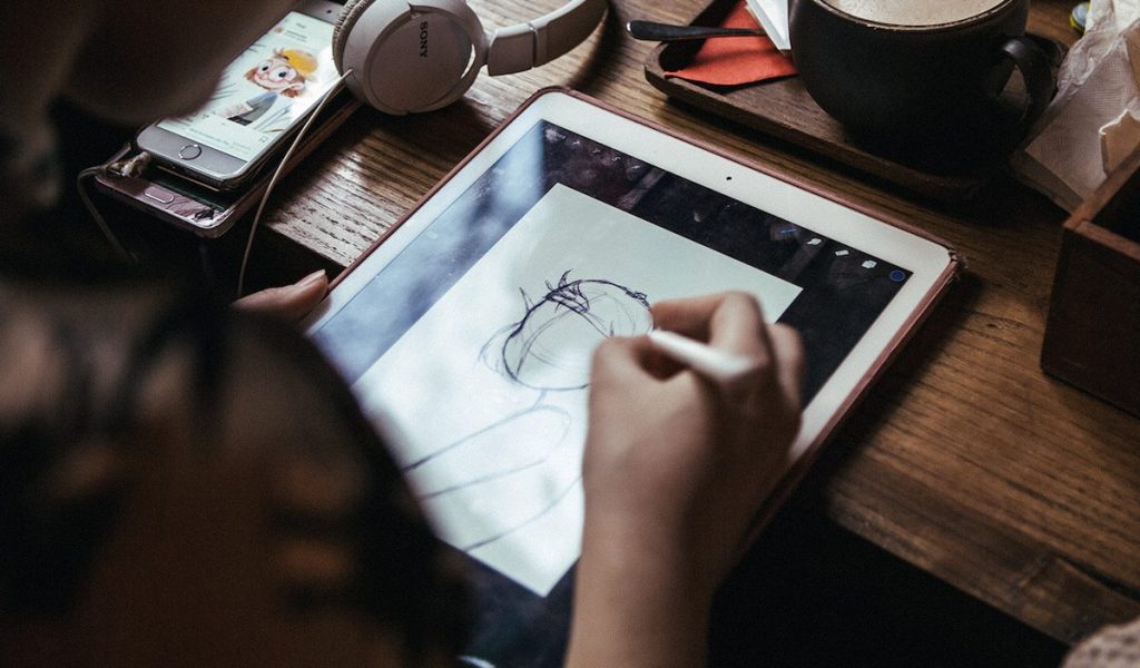 Illustrator creatively sketching on a tablet
