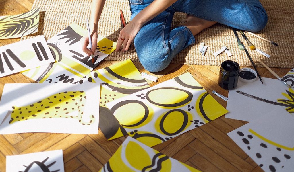 Person painting with vibrant, creative yellows and blacks