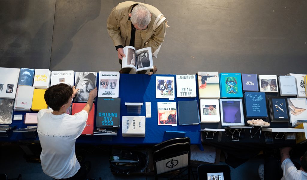 Person reading a book on display at Paris Photo