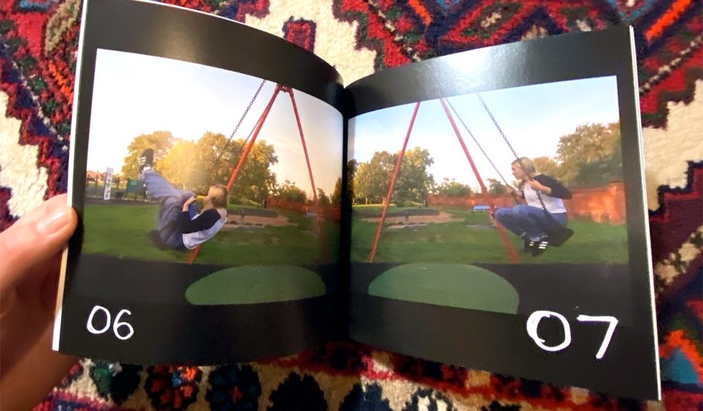 Rose Boakes flipping through the pages of her Wisdom Teeth zine, showing photographs of a person on a swing set in a park setting and handwritten page numbers